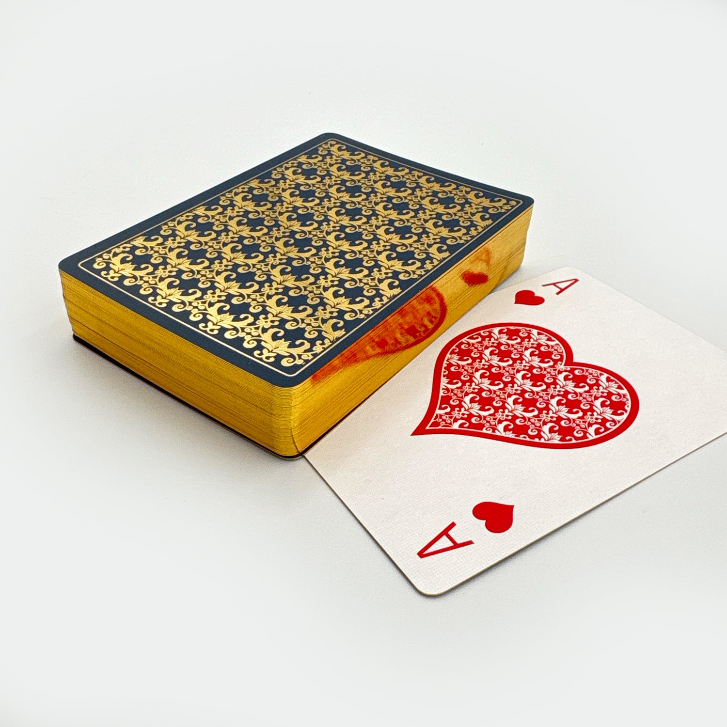Playing card box with a decorative pattern and an Ace of Hearts card on a white background